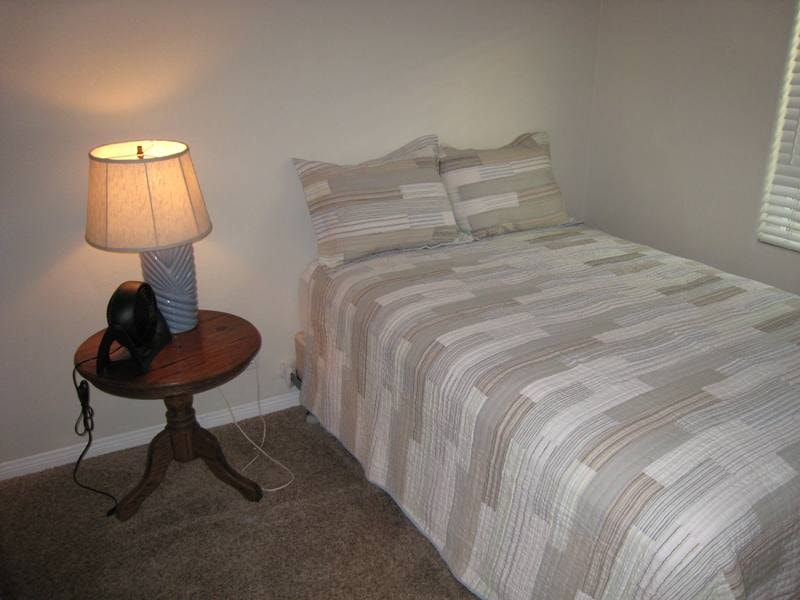 Lower unit second bedroom with queen bed and neutral bedding