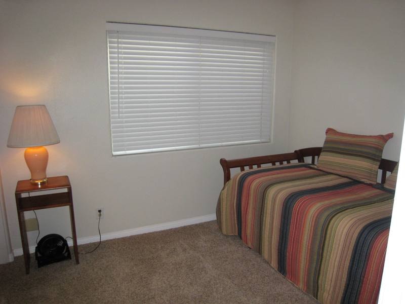 Lower unit third bedroom with twin bed and striped bedding
