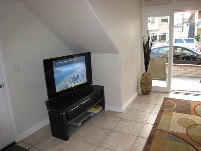 Lower unit living room with flat screen TV and sliding glass door to patio