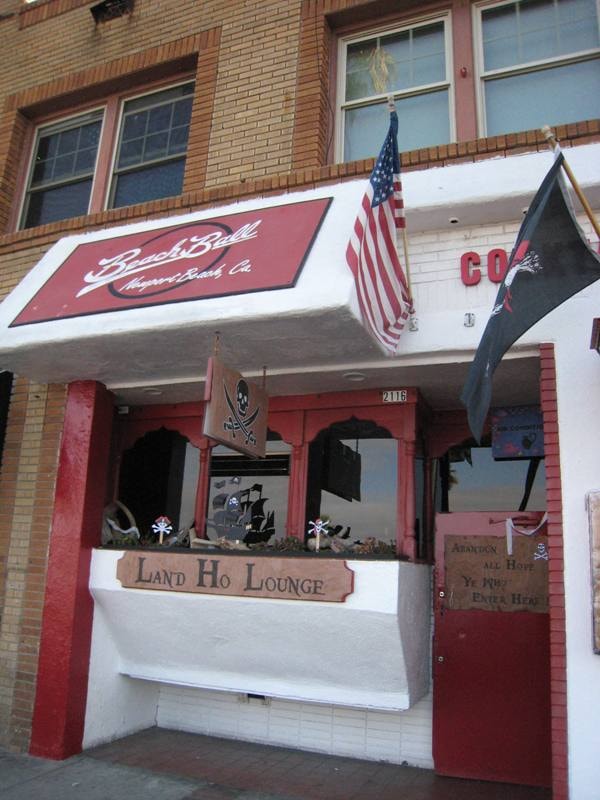 Beach Ball bar and Land Ho Lounge storefront with pirate flags in Newport Beach