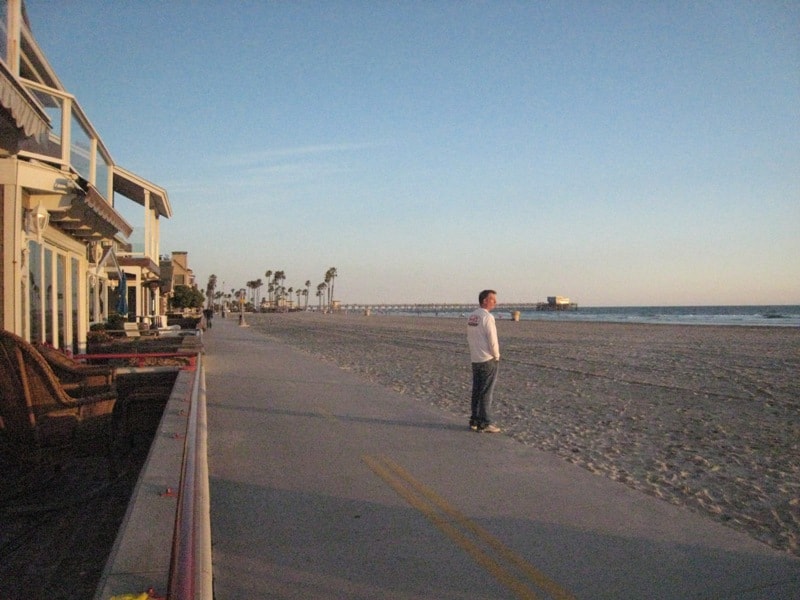 Newport Beach boardwalk looking toward the pier at golden hour