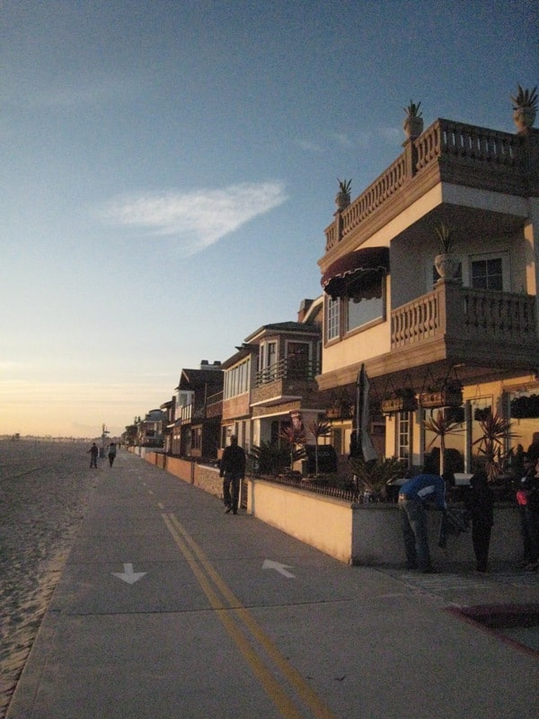 Newport Beach boardwalk at sunset with beachfront homes