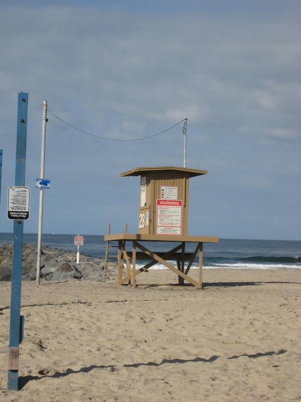 Lifeguard tower 28 on Newport Beach sand with ocean in the background