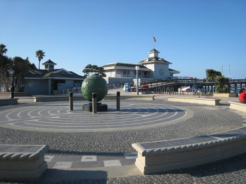 Newport Beach Pier plaza with globe sculpture and cobblestone walkway
