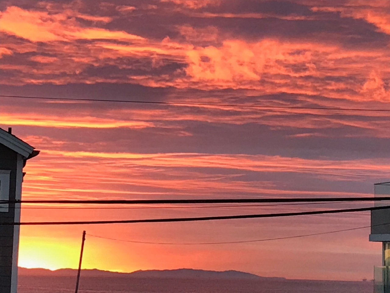 Fiery red and orange sunset sky over Newport Beach rooftops