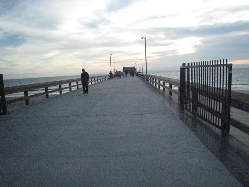 People walking on Newport Beach pier at dusk