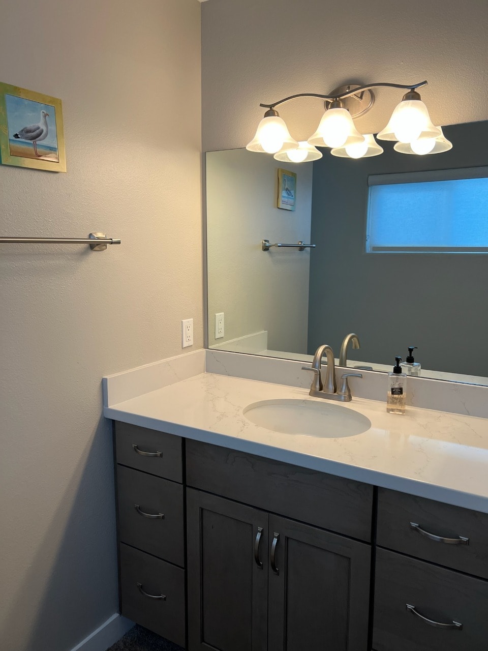 Upper unit second bathroom with marble vanity and coastal seagull art