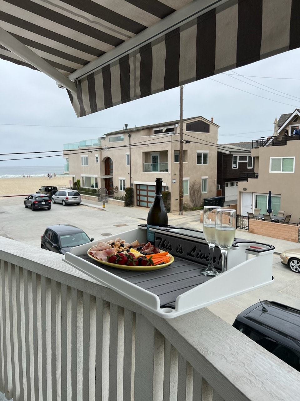 Upper unit deck with charcuterie and wine overlooking the beach