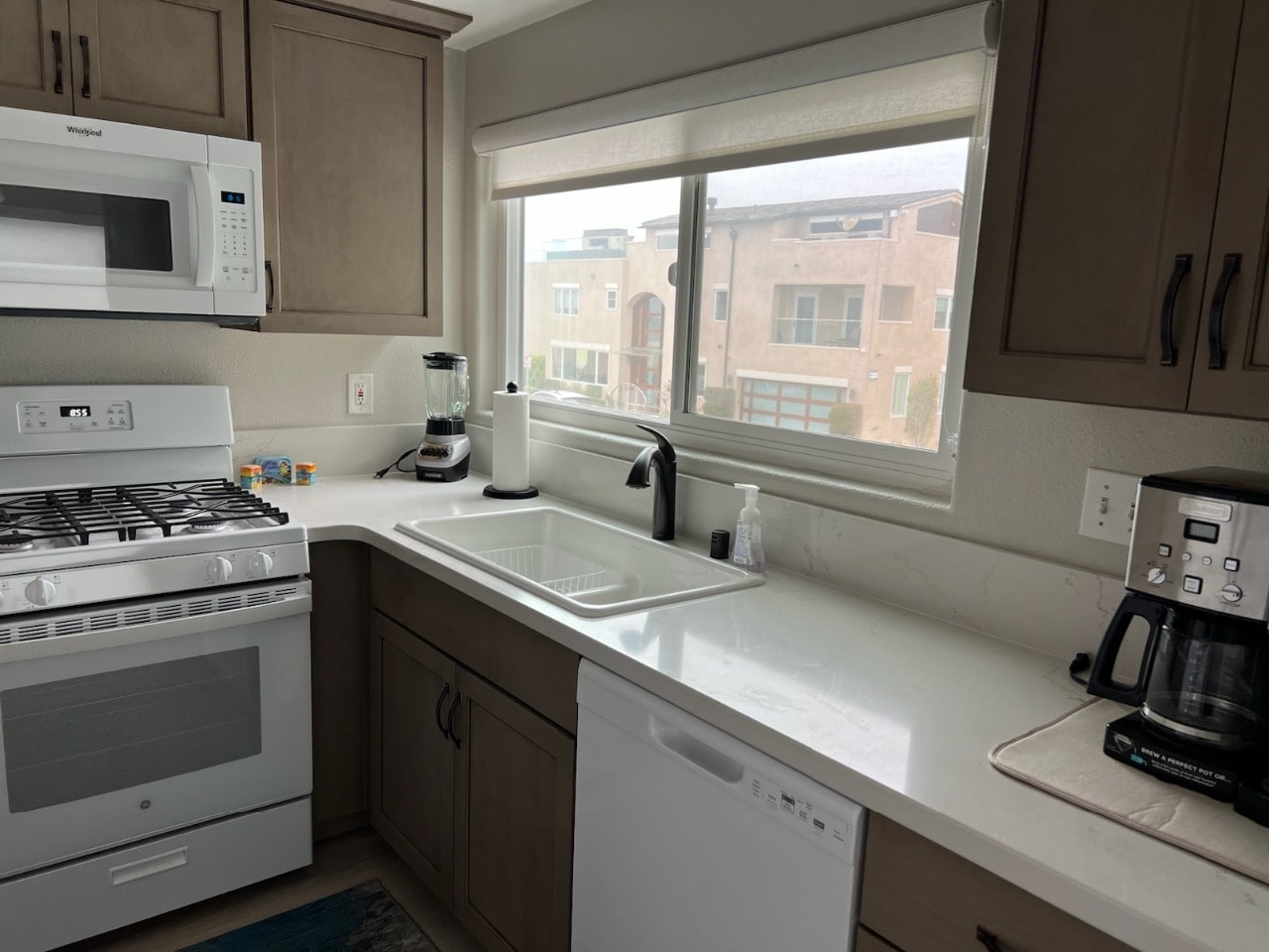 Upper unit kitchen sink area with dishwasher, blender, and coffee maker