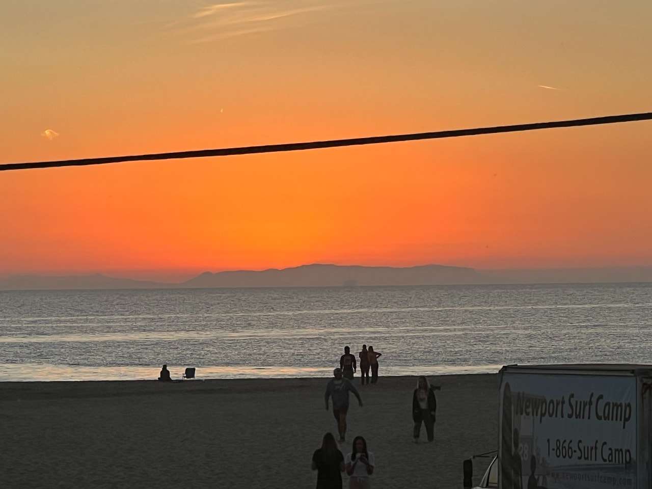 Newport Beach sunset with surfers and beachgoers at Newport Surf Camp